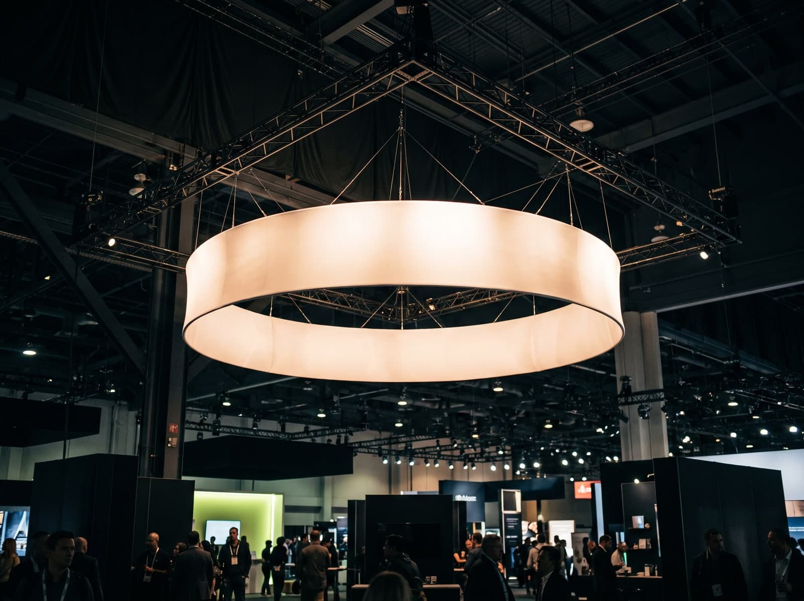 A circular halo hanging fabric sign above a trade show booth